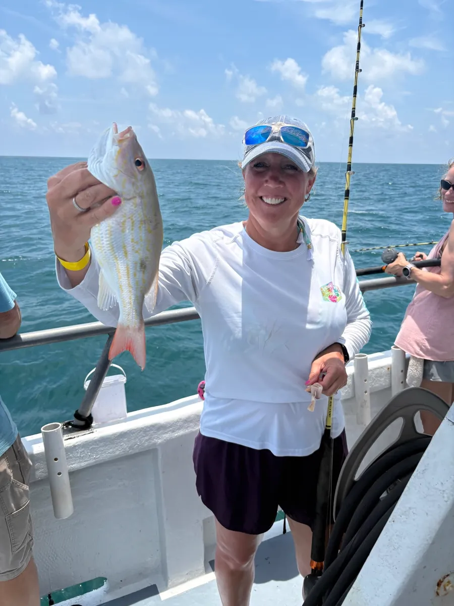 Angler holding a fish caught aboard the Gulfstream party boat off Key West, July 2026.