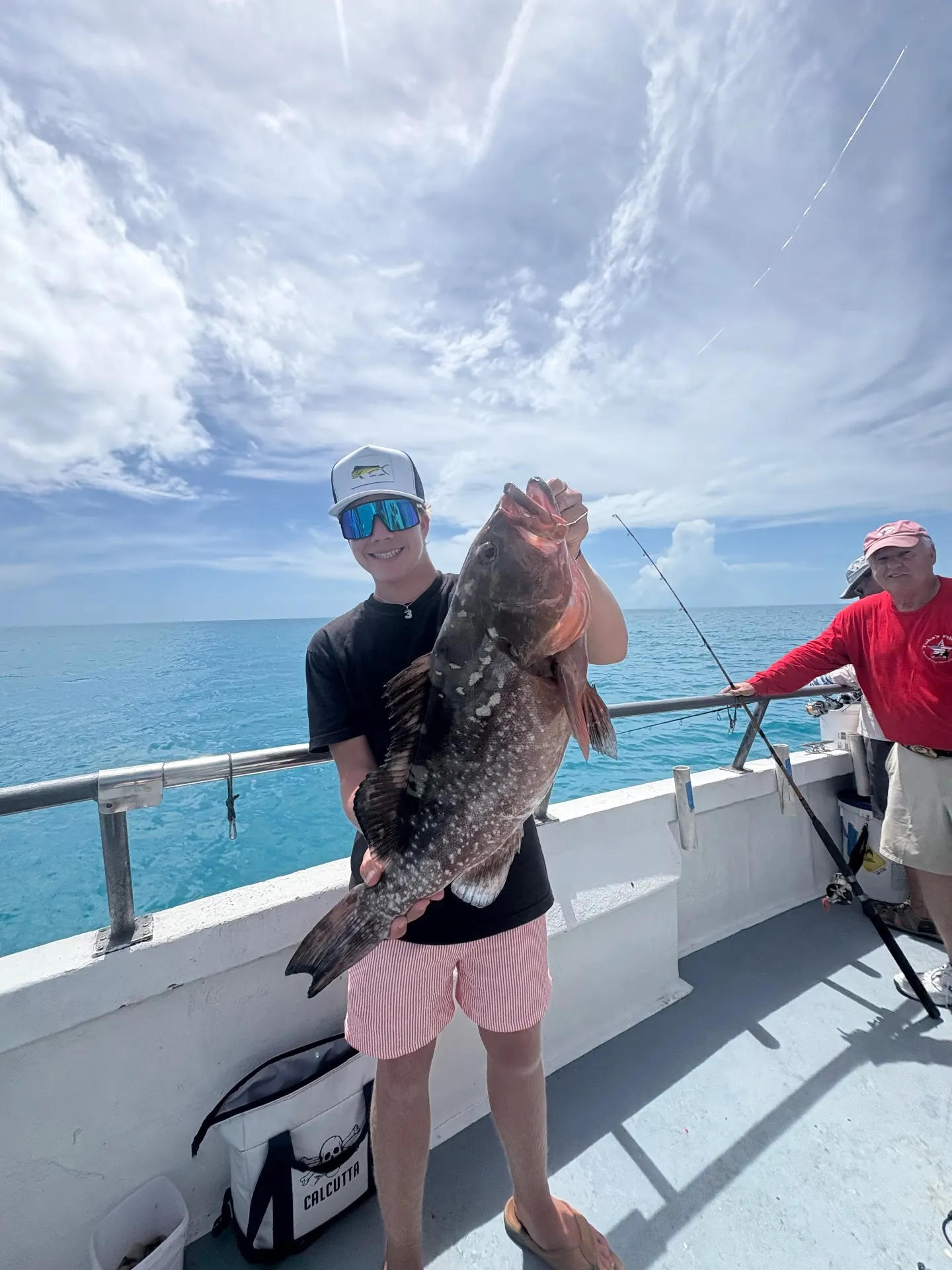 Young angler holding a heavy red grouper caught and released aboard the Gulfstream party boat off Key West, mid-March 2026.