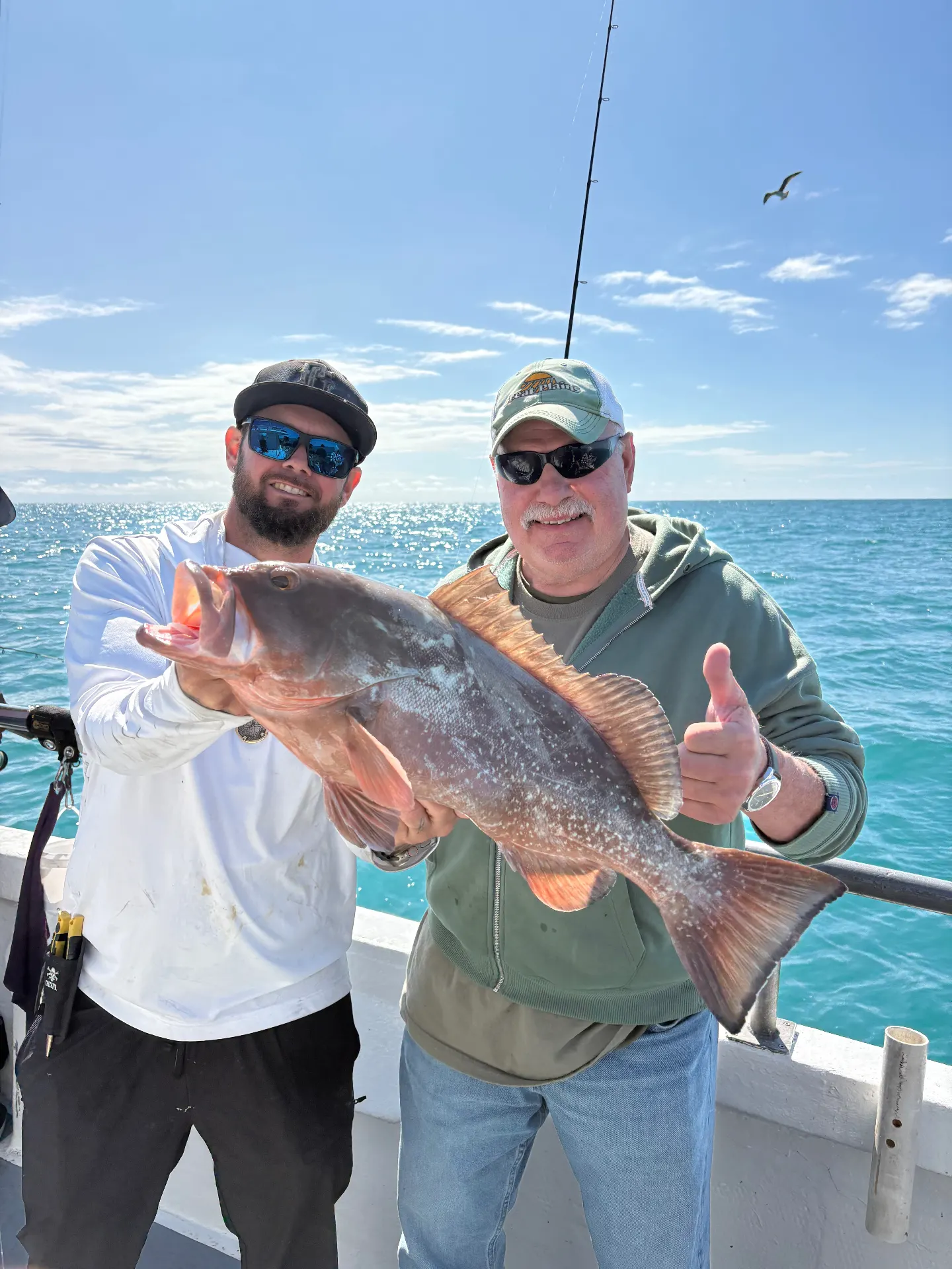 Two anglers holding a heavy red grouper caught on opening day, May 1, 2026, aboard the Gulfstream IV in Key West.