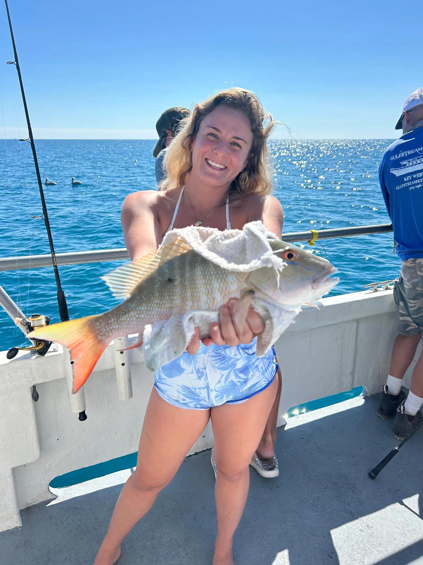 Smiling customer with yellowtail snapper on Gulfstream party boat fishing trip Key West